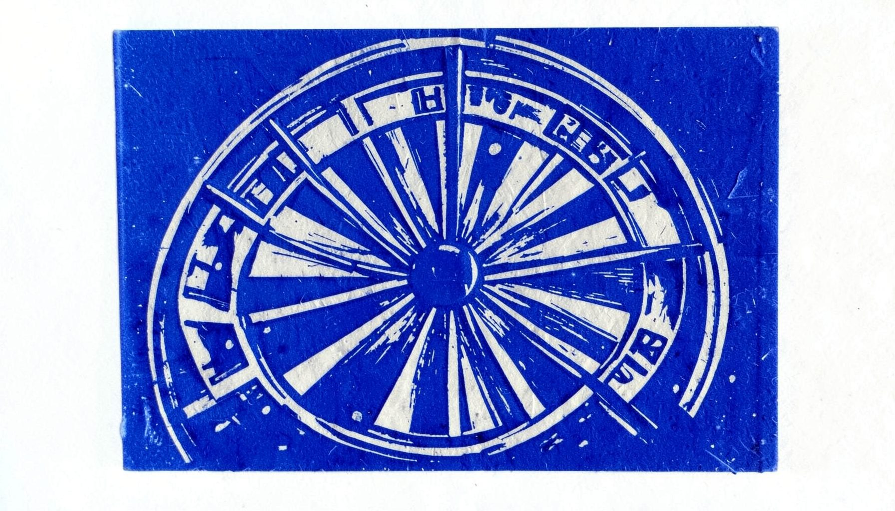 Carved linocut relief print of a roulette wheel segment in indigo and pale gray